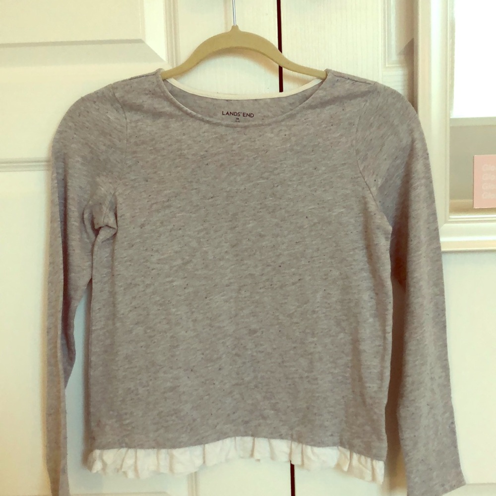 gray crew sweater with white ruffles at bottom